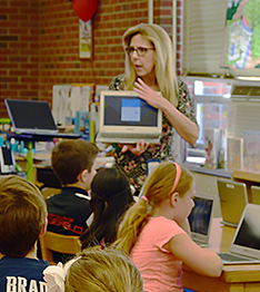 Teacher showing laptops to students